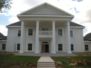 A large white house with columns and steps leading to the front.